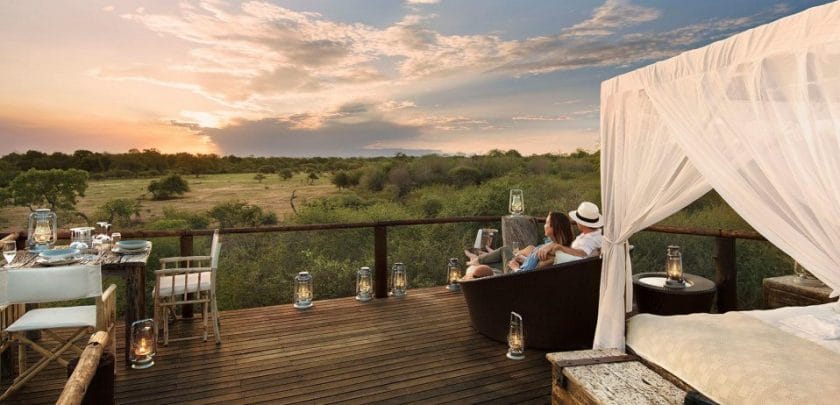 Couple admiring the view from a luxury safari lodge while on honeymoon in Tanzania.