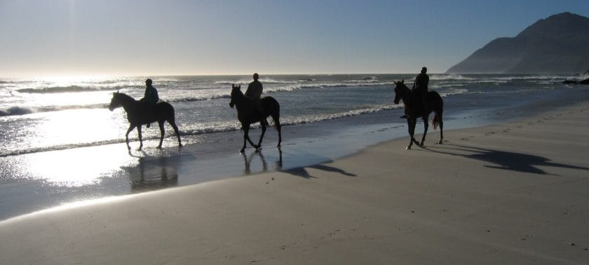 Horse riders on Noordhoek beach in Cape Town, South Africa.