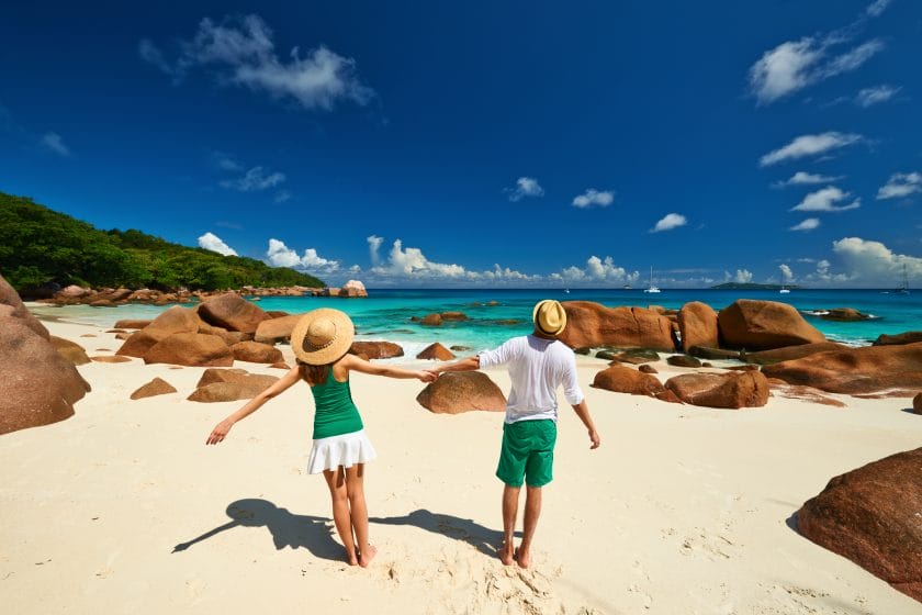 Couple on honeymoon having fun on a tropical beach in Seychelles.