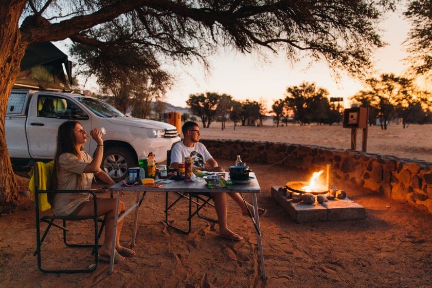 Young couple enjoys a fire at Sesriem Campsite, Namibia.