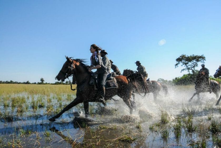 Tourists on African horseback riding through the river | Photo credit: Macatoo