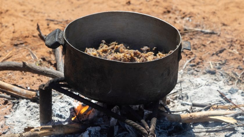 Seswaa, a traditional dish in Botswana, being cooked outdoors.