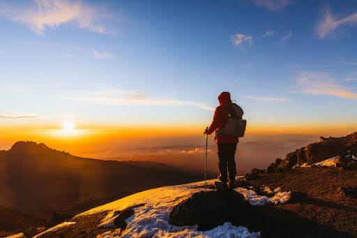 Climber admires the view from Mount Kilimanjaro, Tanzania.