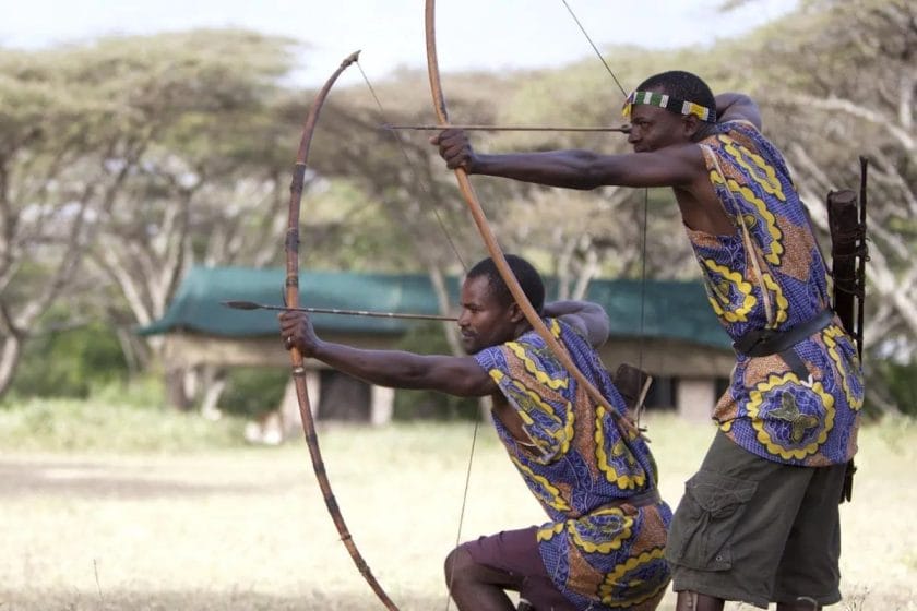 Two Maasai warriors demonstrate their archery skills.